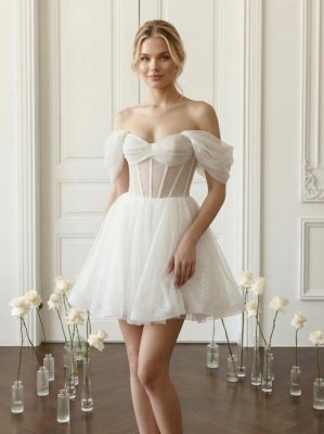 Молочное блестящее мини-платье с прозрачным корсетом и пышными спущенными рукавами.