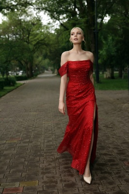 Красное блестящее платье по фигуре с разрезом на ноге и спущенными плечами