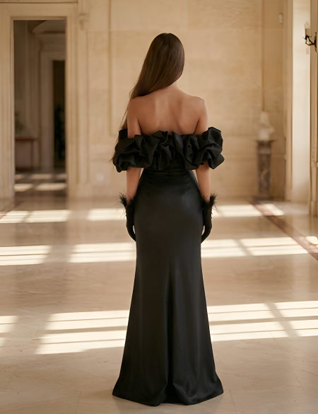 Чёрное платье по фигуре с разрезом на ноге и оборкой